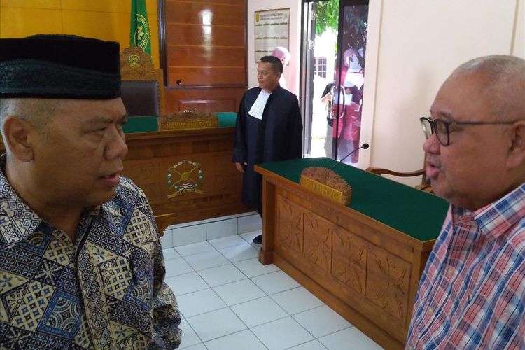 Dwi Irianto alias Mbah Putih (kiri) keluar ruang sidang seusai sidang putusan di Pengadilan Negeri (PN) Banjarnegara, Jawa Tengah, Kamis (11/7/2019).