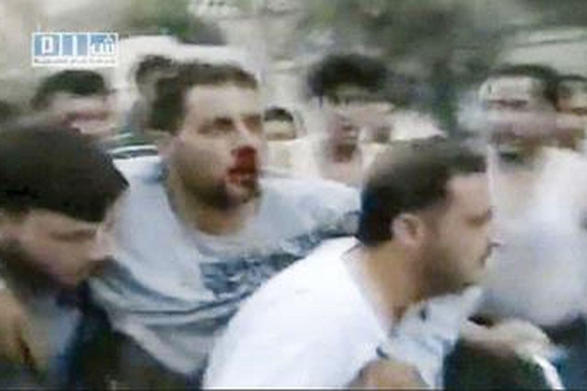 Gambar video amatir yang dirilis Shams News Network, organisasi anti-Presiden Suriah Bashar al-Assad, Minggu (31/7), memperlihatkan seorang pria yang cedera karena serbuan tentara Suriah dipapah rekannya untuk dinaikkan ke sepeda motor di kota Hama.