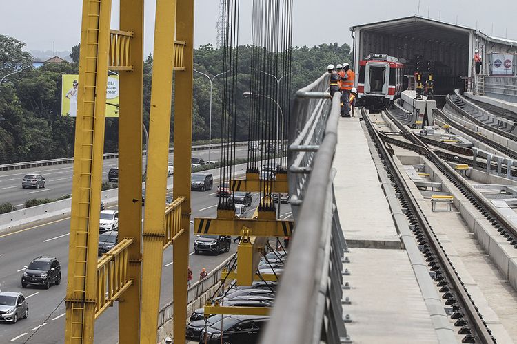 Sejumlah karyawan mengecek keadaan rel dan gerbong kereta layang ringan atau LRT di Stasiun Harjamukti, Depok, Jawa Barat, Minggu (13/10/2019). Progres pembangunan proyek LRT Jabodebek lintas pelayanan 1 Cibubur-Cawang telah mencapai 85,7 persen dan satu rangkaian gerbong LRT telah diangkat dan diparkir di Depo Stasiun Harjamukti.