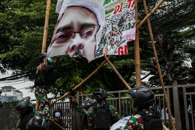 Indonesian Army soldiers take down a banner featuring FPI head Habib Rizieq Shihab in Tanah Abang, Central Jakarta on (20/11/2020)