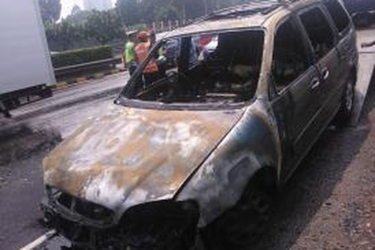 Mobil KIA Carnival hangus setelah terbakar di Tol Dalam Kota, Jakarta, Rabu (3/9/2014).