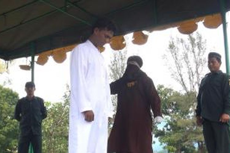 Seorang terpidana pelanggar syariat islam menjalani hukuman cambuk di Jantho, Aceh Besar Jumat (5/12/2014) karena terbukti melanggar qanun no 13 tahun 2003 tentang Maisir. ***** K12-11
