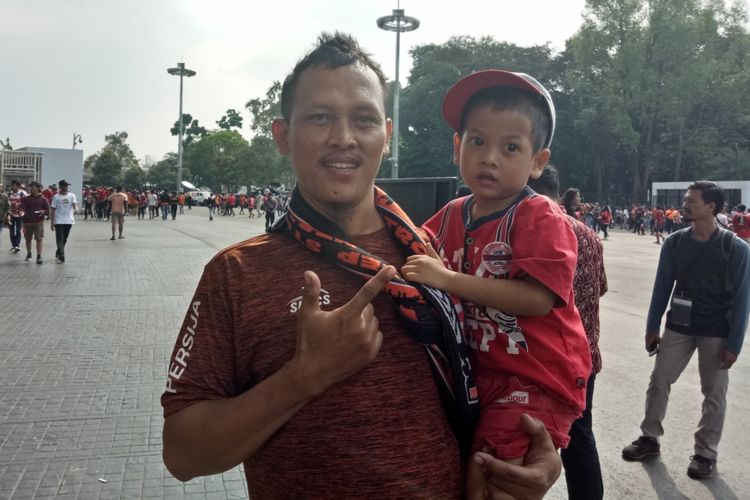 Jaji (35), salah satu The Jakmania asal Tanjung Priok, Jakarta Utara yang membawa anak dan istrinya menyaksikan laga Persija vs Persib Bandung di Stadion Utama Gelora Bung Karno, Jakarta, Rabu (10/7/2019).