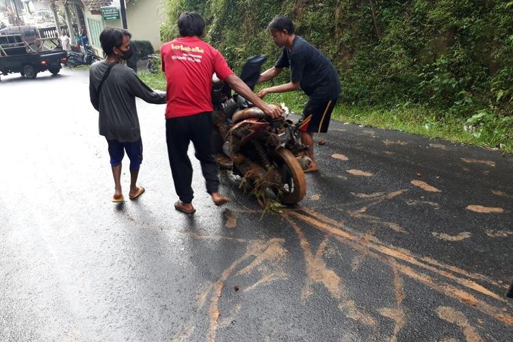 Warga mengevakuasi sepeda motor korban yang tertimpa longsor di jalan Desa Gununglurah, Kecamatan Cilongok, Kabupaten Banyumas, Jawa Tengah, Rabu (17/11/2021) sore.