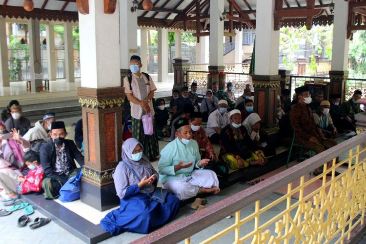 Para peziarah melantunkan doa dan tahlil saat berziarah di kompleks makam keluarga Pesantren Tebuireng, Jombang, Jawa Timur, Senin (1/11/2021).