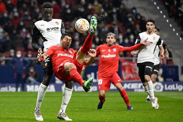 Bek Valencia Mouctar Diakhaby (kiri) menjaga striker Atletico Madrid Luis Suarez pada laga Liga Spanyol antara Atletico Madrid vs Valencia CF di Stadion Wanda Metropolitano di Madrid pada 22 Januari 2022.