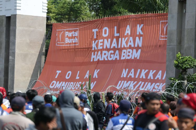 Massa dari elemen buruh melakukan demonstrasi di depan Gedung DPR/MPR RI, Jakarta, Selasa (6/9/2022). Mereka memasang spanduk berukuran besar hingga menutupi gerbang masuk utama kompleks parlemen untuk menolak kenaikan harga BBM.