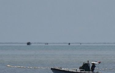 Foto yang diambil pada 22 September 2023 ini menunjukkan personel pasukan penjaga pantai China berada di atas perahu karet lambung kaku mereka di samping penghalang terapung saat mereka menjaga jalur menuju Scarborough Shoal yang dikuasai China di perairan Laut China Selatan yang disengketakan. Tiongkok, yang mengklaim kedaulatan atas hampir seluruh Laut Cina Selatan, merebut kendali atas Scarborough Shoal dari Filipina pada tahun 2012. Sejak saat itu, China telah mengerahkan kapal penjaga pantai dan kapal-kapal lain untuk memblokir atau membatasi akses ke daerah penangkapan ikan yang telah dimanfaatkan oleh beberapa generasi warga Filipina. 