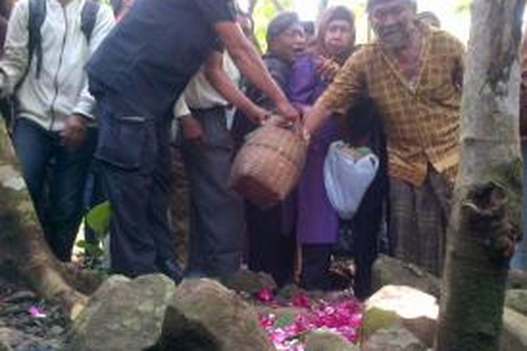 Sanak keluarga dari eks korban 1965 menaburkan bunga di atas liang lahat. Seluruh korban yang jumlahnya berjumlah 24 orang dikubur dalam dua liang lahat.