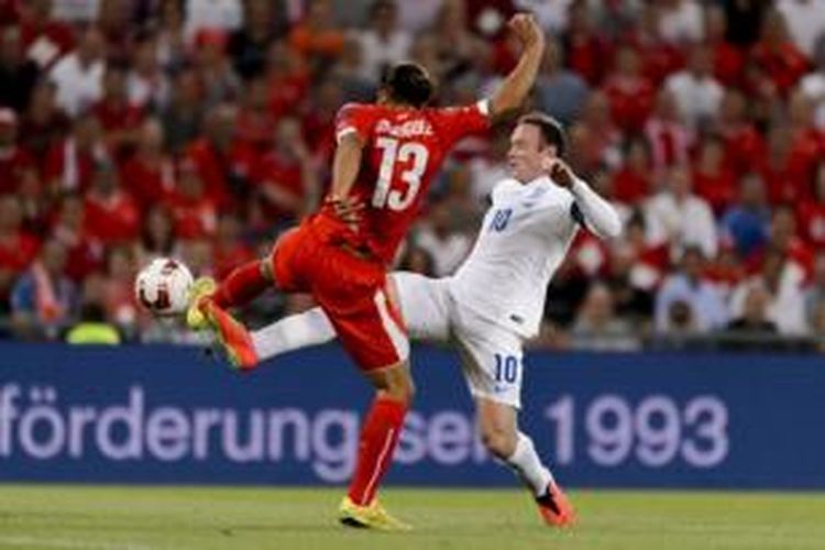 Striker Inggris, Wayne Rooney (kanan), berebut bola dengan bek Swiss, Ricardo Rodriguez (kanan), dalam laga Kualifikasi Piala Eropa 2016 Grup E di Stadion St Jakob Park, Basel, Senin (8/9/2014).