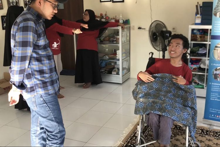 Penyandang disabilitas tuna daksa sekaligus anggota Sanggar Inspirasi Karya Inovasi Difabel (Sriekandi Patra) Darmawan Fadli Abdul Syukur (19) atau akrab disapa Wawan memamerkan karya batik tulis buatannya di workshop di wilayah Dukuh Penjalinan, Desa Tawangsari, Boyolali, Jawa Tengah pada Rabu (26/7/2023). Sriekandi Patra merupakan sanggar binaan PT. Pertamina Terminal BBM Boyolali untuk membuka jalan para difabel untuk berkarya lewat batik. PT. Pertamina Terminal BBM Boyolali menghadirkan program Difablepreneur lewat Sriekandi Patra untuk meningkatkan taraf hidup para penyandang disabilitas di Desa Tawangsari melalui sektor Usaha Mikro Kecil Menengah (UMKM) Batik.
