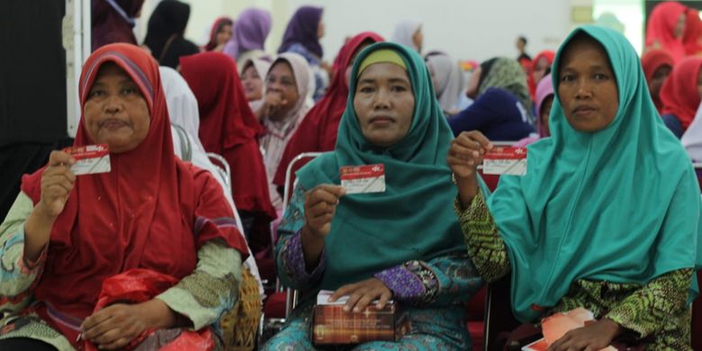 Ibu-ibu Keluarga Penerima Manfaat menunjukkan Kartu Keluarga Sejahtera (KKS) saat acara penyaluran  Bantuan Pangan Non Tunai (BPNT) kepada Keluarga Penerima Manfaat (KPM) di Asramah Haji Donohudan, Kabupaten Boyolali, Jumat (1/2/2019).
 
