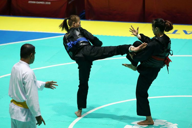 Atlet pencak silat putri Indonesia, Wita Wewey (biru), bertanding melawan pesilat asal Vietnam, Tran Thi Them (merah), pada partai final kelas B putri 50 kg sampai 55 kg Asian Games 2018 di Padepokan Pencak Silat, TMII, Jakarta, Rabu (29/8/2018). Ada berbagai jenis tendangan dalam pencak silat, dua di antaranya adalah tendangan lurus dan tendangan T.