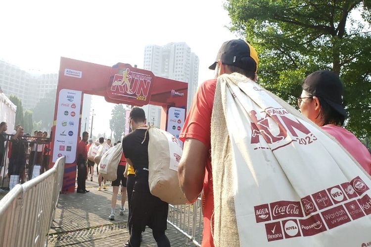 Peserta Alfamart Run 2023 pun antusias menerima goodie bag berisi produk senilai 1,5 juta rupiah dalam karung berukuran 1 meter.