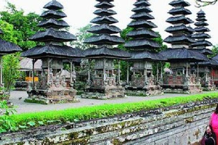 Seorang wisatawan asing berkeliling menikmati keindahan Pura Taman Ayun, Kabupaten Badung, Bali, akhir Agustus 2012. Selain pengunjung yang ingin bersembahyang, pengunjung lain hanya bisa menikmati keindahan pura dari luar pagar. Pura ini dibangun pada abad ke-17 oleh Raja Mengwi Tjokorda Sakti Blambangan dan menjadi bagian dari Warisan Budaya Dunia. 