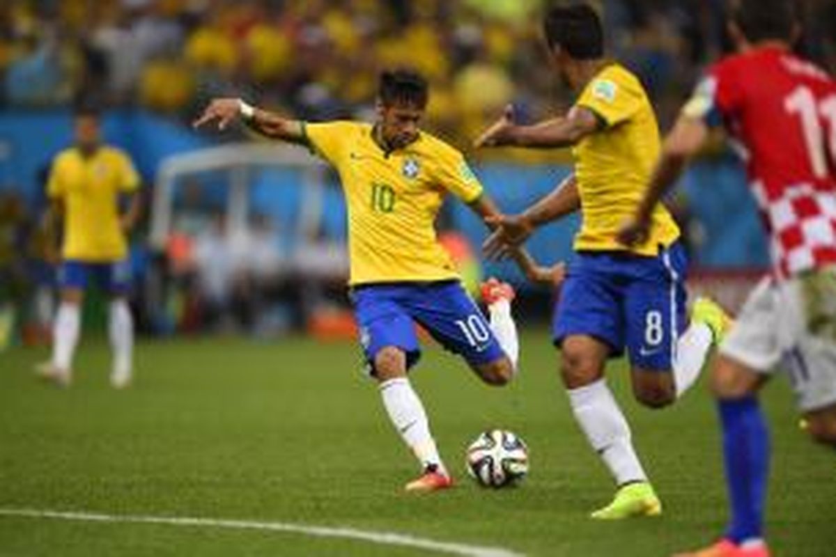 Penyerang Brasil Neymar (kiri) melepaskan tembakan yang berujung gol ke gawang Kroasia, pada laga perdana Grup A Piala Dunia, di di Arena Corinthians, Sao Paolo, Kamis (12/6/2014). 