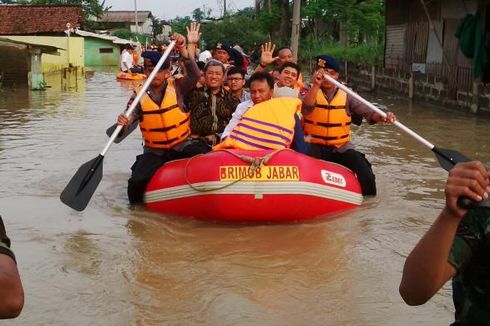 Aher Naik Perahu LIhat Banjir yang Rendam Kabupaten Bandung 