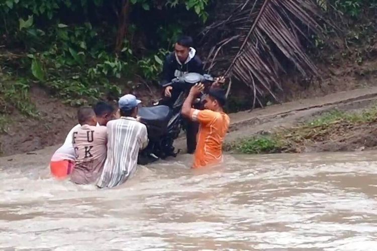 Sejumlah warga di Desa Karyamukti, Kecamatan Leles, Kabupaten Cianjur, Jawa Barat tengah menyebrangkan sepeda motor di tengah arus deras sungai Ciderma. Warga terpaksa menantang maut untuk beraktivitas karena tidak ada infrastruktur jembatan.