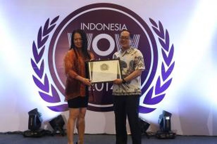 Michael Hermawan, Deputi CEO MarkPlus, Inc. memberikan penghargaan WOW Brand 2014 kategori Residential Property Developer-Asset kepada Rosmalia Hardman (Chief Marketing Officer Divisi Hospitality & Leisure PT Lippo Karawaci Tbk), Kamis (11/9/2014).  