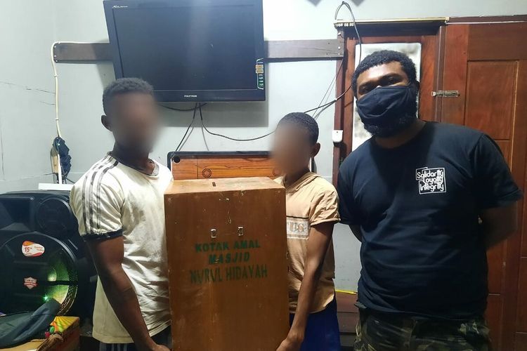 CTK dan YK saat menunjukan kotak amal yang mereka curi dari sebuah tempat ibadah, Jayapura, Papua, Selasa (23/3/2021)