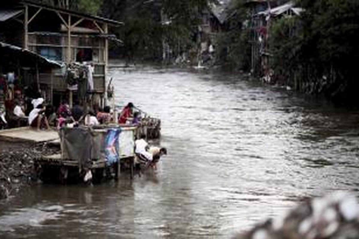 Anak-anak mencuci muka di Kali Ciliwung yang penuh dengan hunian di Kampung Pulo, Kelurahan Kampung Melayu, Kecamatan Jatinegara, Jakarta Timur, Minggu (15/2/2015). Pencemaran sungai di Jakarta sudah jauh di atas ambang batas yang diisyaratkan. bahkan, dari sekitar 807.000 pelanggan air dari dua perusahaan air minum di DKI Jakarta, hampir 300.000 di antaranya tidak terlayani.