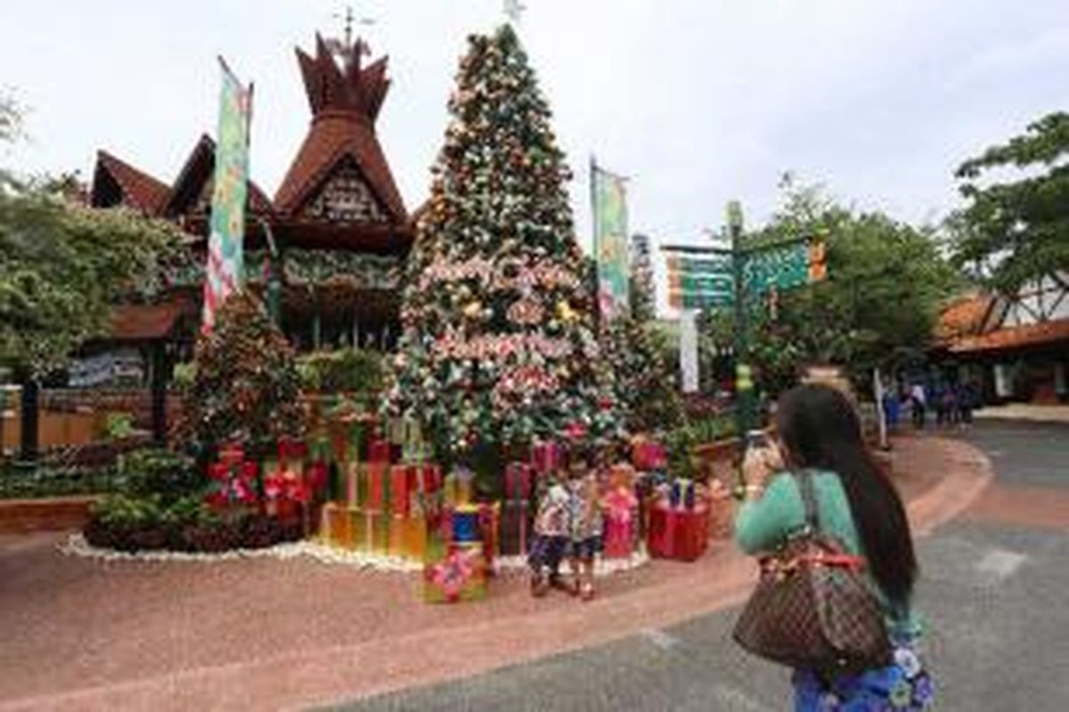 Pengunjung Dunia Fantasi tengah berfoto di depan pohon Natal di Ancol, Jakarta Utara, Jumat (20/12/2013). Menjelang perayaan Natal dan Tahun baru 2014, sejumlah tempat rekreasi mulai menghiasi untuk meyemarakkan momen Natal. 