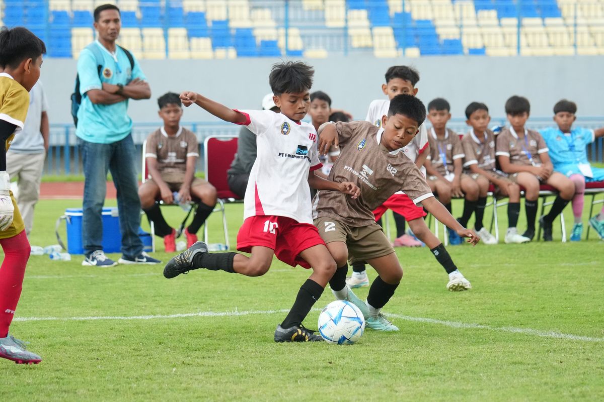 Aksi perebutan bola antara pemain  Peganden FC dan SSB Gressia pada  pertandingan final kategori U-12 Freeport Grassroots Tournament 2026.