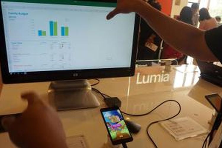 Smartphone Lumia 950 tetap bisa digunakan secara normal saat terhubung dengan monitor eksternal. Di foto ini nampak file Excel dibuka di monitor dan game Candy Crush sedang dimainkan di smartphone.
