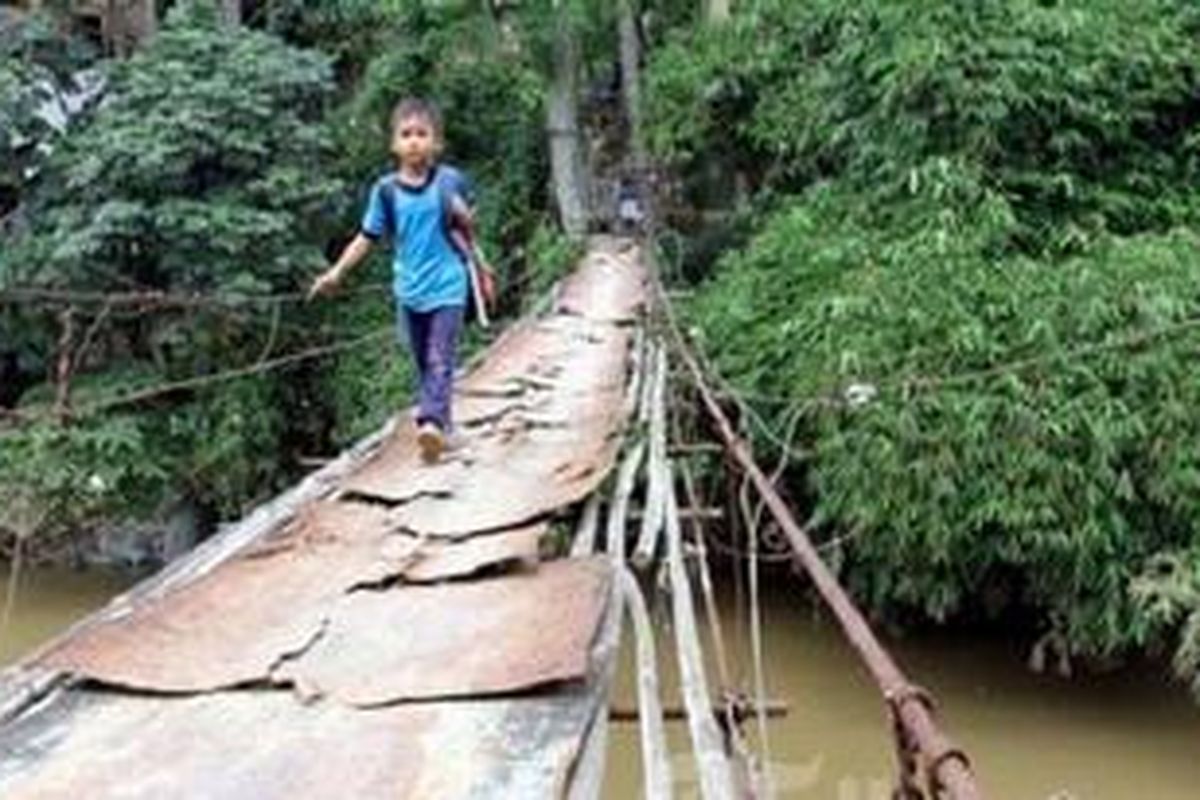Siswa SD dan warga melintasi jembatan gantung di atas Sungai Ciliwung, dari Kelurahan Pasir Gunung Selatan, Cimanggis, Depok, Jawa Barat, menuju Srengseng Sawah, Jagakarsa, Jakarta Selatan, Selasa (4/12/2012). Mereka terpaksa menyeberang melintasi jembatan gantung untuk berangkat ke sekolah atau beraktifitas.