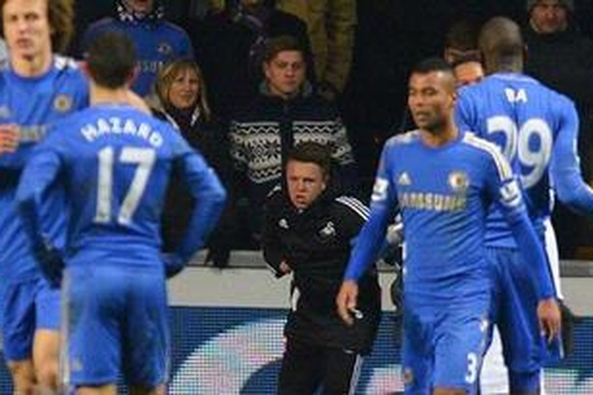 Seorang anak gawang Swansea City (tengah) berdiri tertatih-tatih setelah jatuh di lapangan menyusul insiden sepakan gelandang Chelsea dari Belgia, Eden Hazard, dalam semifial kedua Piala Liga Inggris. Hazard akhirnya diberi kartu merah akibat perbuatannya oleh wasit Chris Foy. Pertandingan itu berakhir 0-0 dan Swansea unggul agregat 2-0. 