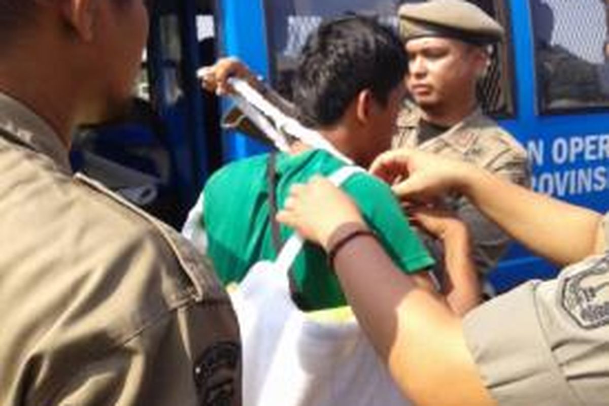 Petugas Satpol PP mengamankan badut yang mengamen di kawasan Monas, Jakarta Pusat. Sabtu (2/8/2014).