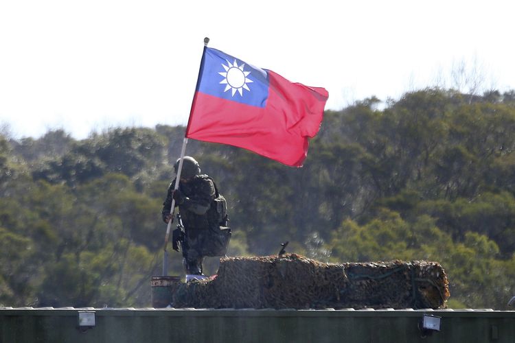 Foto 19 Januari 2021 ini menunjukkan seorang tentara memegang bendera Taiwan selama latihan militer untuk melawan serangan China di Hsinchu, Taiwan utara.