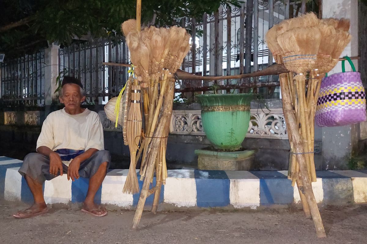 Dulrasu (73) bersama pikulan berisi sapu ijuk yang dia ajakan dengan cara berjalan kaki. Usaha ini sudah bertahun-tahun dijalani di wilayah Sumenep, Madura. Meski usianya sudah senja, dia pernah tidak ingin merepotkan kerabat bahkan kedua anak kandungnya, dia tetap gigih berusaha untuk hidupnya. 
