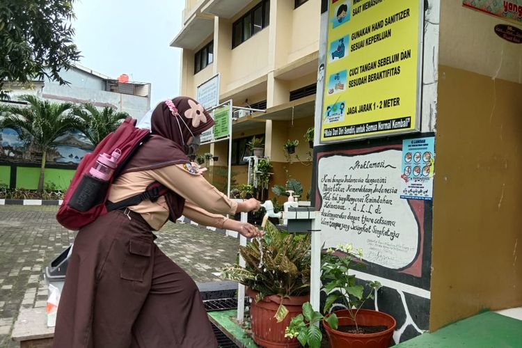 Seorang siswa SDN Pondok Kelapa 05 Pagi tengah mencuci tangan usai kegiatan uji coba sekolah tatap muka di Jakarta Timur, Rabu (7/4/2021).