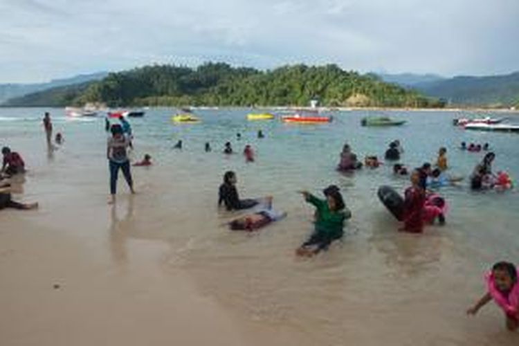 Wisatawan menikmati keindahan pantai pasir putih di Pulau Cingkuak, Kecamatan IV Jurai, Kabupaten Pesisir Selatan, Sumatera Barat, Jumat (15/5/2015). Pulau Cingkuak yang berdekatan dengan Pantai Carocok menyediakan wahana air seperti banana boat dan flying fish. 