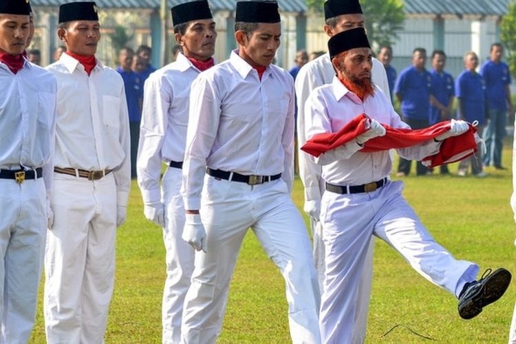 Umar Patek membawa bendera pada upacara memperingati Hari Kebangkitan Nasional (Harkitnas) di Lapas Porong, Sidoarjo, Jawa Timur, tahun 2015 setelah berikrar setia pada NKRI.