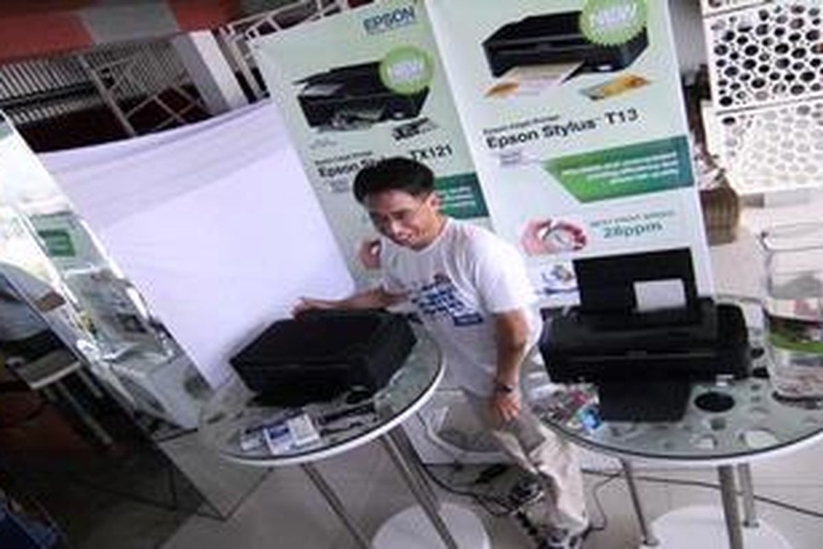 Country Manager PT Epson Indonesia Hirasaki Michiya berpose dengan dua printer ekonomis yang baru diluncurkan Epson di Kuta, Bali, Sabtu (12/6/2010).