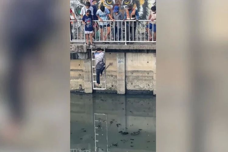Tangkapan layar yang menunjukkan seorang pemuda mengecek dugaan jenazah yang mengambang di saluran air di Bangkok, Thailand. Setelah didekati, rupanya pria yang sedang bermeditasi.