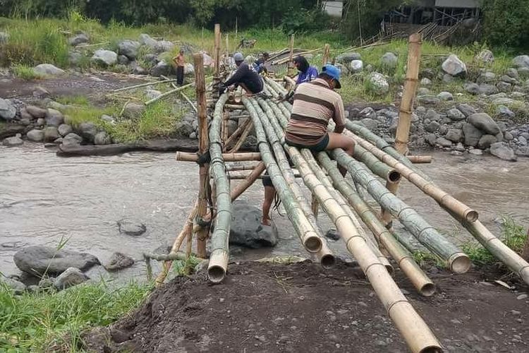 Warga sedang memperbaiki jembatan sememu secara swadaya, Senin (14/3/2022)