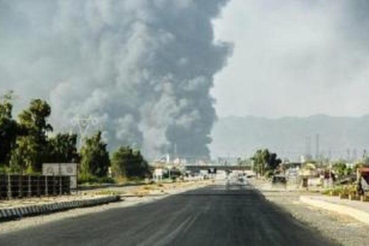 Kepulan asap membubung tinggi di sebuah kilang minyak di Beiji, sekitar 250 kilometer sebelah utara Baghdad, Irak, setelah sebuah serangan yang dilancarkan ISIS. 