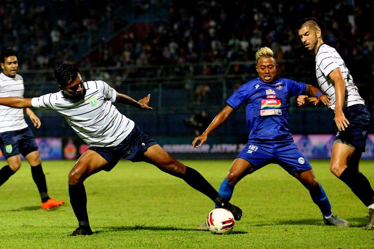 Penyerang Arema FC, Kushedya Hari Yudo (tengah) diapit dua pemain Persela Lamongan pada laga kedua Grup B Piala Gubernur Jawa Timur 2020 di Stadion Kanjuruhan, Malang, Kamis, 13 Februari 2020.