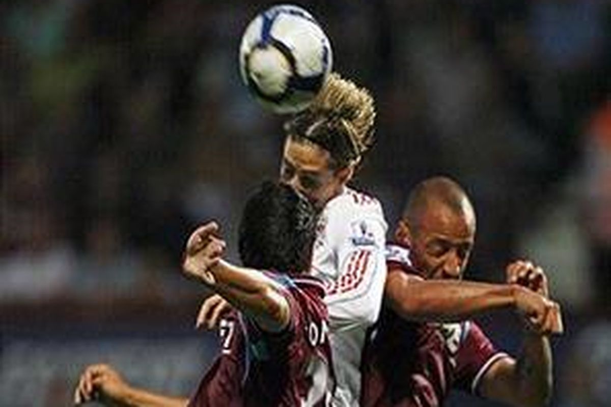 Penyerang Liverpool, Fernando Torres (tengah) berhasil mengatasi adangan sepasang bek West Ham United, James Tomkins dan Julien Faubert untuk menyundul bola masuk ke gawang Robert Green. Liverpool pun membawa pulang kemenangan 3-2 dari Upton Park.