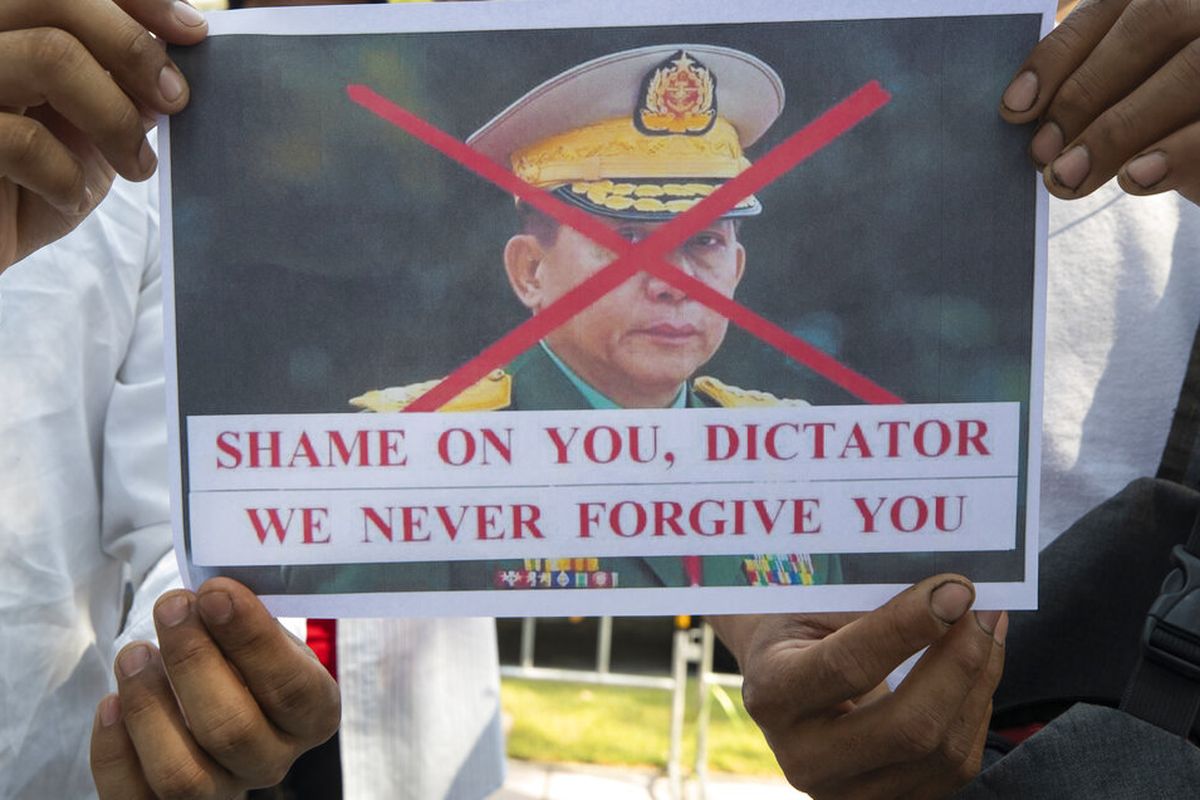Warga negara Myanmar yang tinggal di Thailand memegang foto yang mengecam Panglima Tertinggi militer Myanmar Jenderal Min Aung Hlaing, selama protes di depan gedung PBB di Bangkok, Thailand, Rabu (3/2/2021).