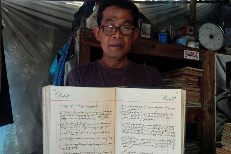 Bambang Tri Harjanto, ketua paguyuban pedagang Taman Buku dan Majalah Alun-alun Utara Keraton Surakarta menunjukkan buku kuno keluaran tahun 1836, Selasa (18/9/2018).