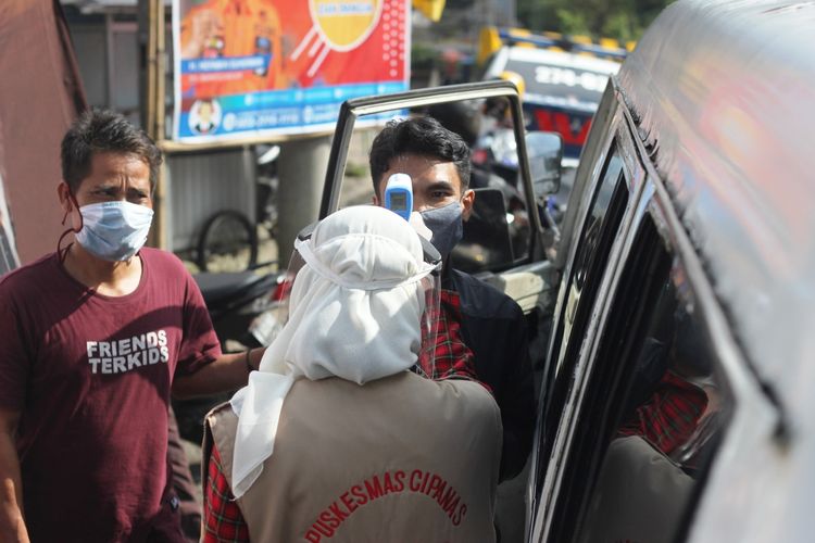 Petugas check point 1 Segar Alam Ciloto, Cipanas Cianjur, Jawa Barat, memeriksa suhu tubuh penumpang angkutan colt Bogor-Cianjur yang kedapatan tinggi, Sabtu (30/5/2020)