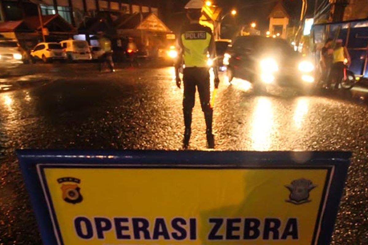 Polisi lalu-lintas menghentikan pengendara sepeda motor saat Operasi Zebra Rencong 2019 di lintas Nasional Medan-Banda Aceh, Lhokseumawe, Aceh, Sabtu 26/10/2019).  Selain sasaran tujuh poin utama tilang pelangaran lalu lintas, Operasi Zebra menjelang tengah malam itu juga menyasar senjata api, senjata tajam, bahan peledak, identitas diri (DPO Polisi) dan peredaran narkotika.