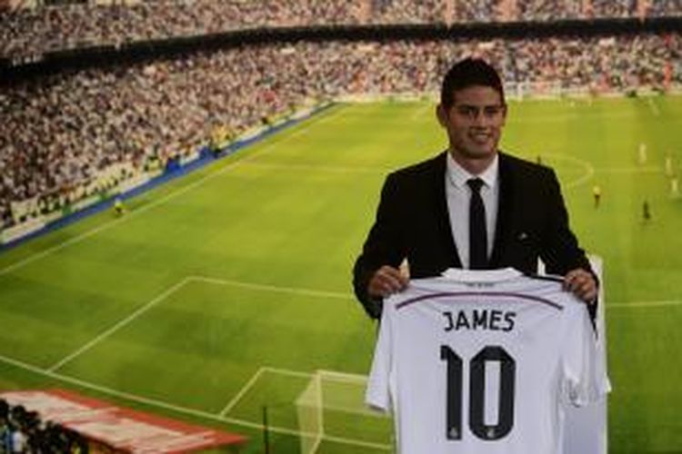 Penyerang asal Kolombia, James Rodriguez, berpose saat diperkenalkan di Santiago Bernabeu usai menandatangani kontrak berdurasi enam tahun dengan Real Madrid, Selasa (22/7/2014).