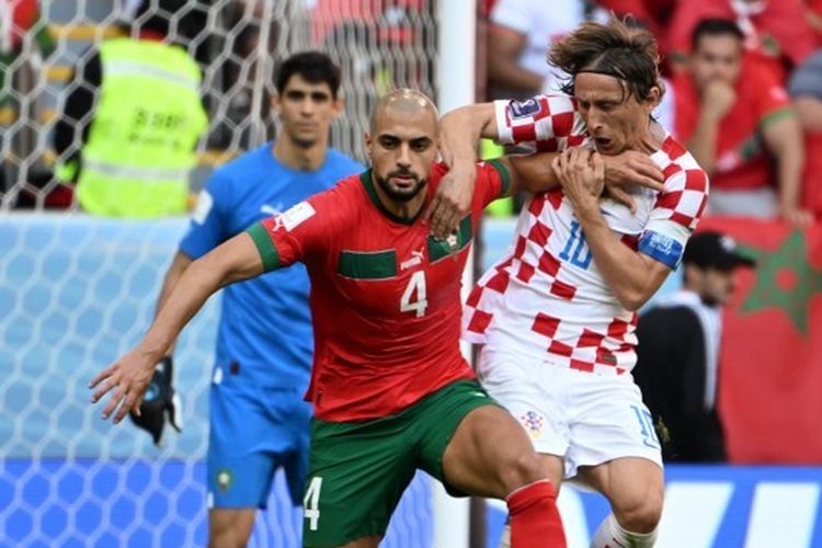 Gelandang timnas Kroasia, Luka Modric (kanan), berebut bola dengan pemain timnas Maroko, Sofyan Amrabat, dalam laga Grup F Piala Dunia 2022 Qatar. Laga Maroko vs Kroasia tersebut dilangsungkan di Stadion Al Bayt, Al Khor, pada Rabu (23/11/2022) sore WIB.