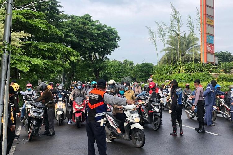 Hari kedua pembatasan sosial berskala besar (PSBB) di Surabaya, arus lalu lintas di perbatasan Surabaya dan Sidoarjo, Jawa Timur, tepatnya di Bundaran Waru, terpantau lancar, Rabu (29/4/2020). Meski kendaraan terlihat padat, arus lalu lintas terpantau lancar.