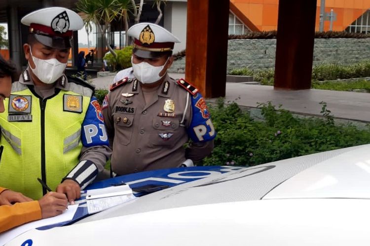 Pengendara motor yang masuk ke jalan tol Jombang - Mojokerto, diminta petugas menandatangani pernyataan setelah dihentikan petugas PJR Polda Jawa Timur, Senin (14/2/2022).